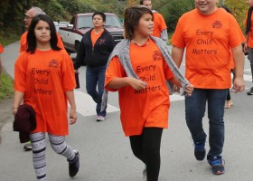 Children walk with survivors for Orange Shirt Day commemoration